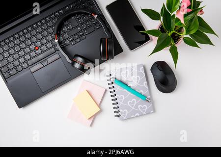 Espace de travail et bureau avec ordinateur portable, casque et smarthpone. Mise à plat sur fond blanc Banque D'Images