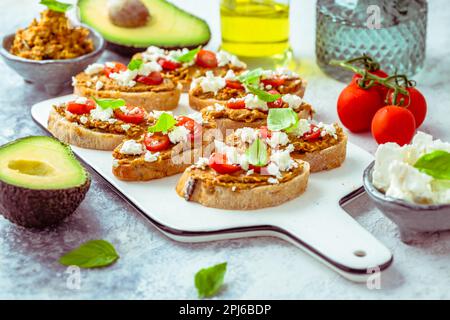 Bruschetta ou sandwichs ouverts ciabatta avec avocat et tartinade aux tomates et feta Banque D'Images