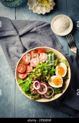 Saladier avec thon, œuf, tomate et oignons - nourriture saine Banque D'Images