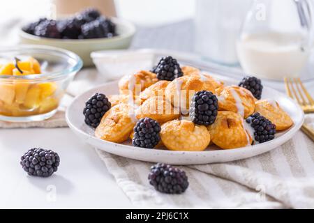 Mini crêpes hollandaises appelées poffertjes avec mûres et compot aux pommes Banque D'Images