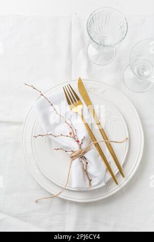 Placez le décor dans des assiettes blanches, des couverts en or et une serviette en papier Banque D'Images