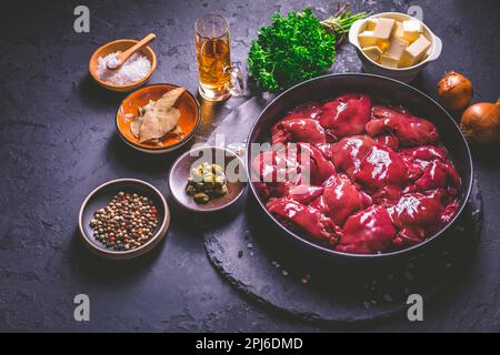 Foie de poulet cru avec des ingrédients de cuisson pour le pâté de foie, les herbes et le brandy Banque D'Images
