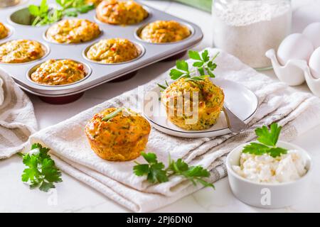 Délicieux muffins au courgettes maison avec fromage feta sur une table de cuisine blanche Banque D'Images