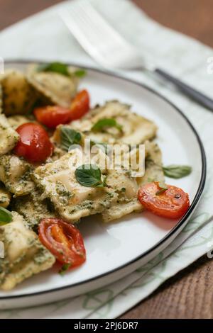 Ravioli végétalien avec pesto de noyer et tomates cerises Banque D'Images