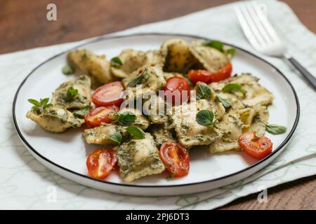 Ravioli végétalien avec pesto de noyer et tomates cerises Banque D'Images