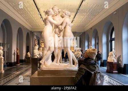 Visiteurs dans les galeries de sculpture du V&A aka Victoria and Albert Museum à côté des trois grades par Antonio Canova le 7th mars 2023 à Londres, Royaume-Uni. Le Victoria and Albert Museum est connu comme le plus grand musée d'arts appliqués, d'arts décoratifs et de design au monde, avec des collections d'une portée et d'une diversité inégalées. Depuis plus de 3000 ans, la collection contient des objets provenant de nombreuses cultures parmi les plus riches au monde, notamment la céramique, le mobilier, la mode, le verre, la bijouterie, métallurgie, photographies, sculpture, textiles et peintures. Antonio Canova était un sculpteur italien néoclassique, famou Banque D'Images