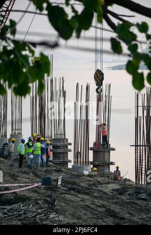 Guwahati, Inde. 27 mars 2023. Les ouvriers de la construction se sont occupés à fabriquer un poteau en béton près de la rivière Brahmaputra à Guwahati Banque D'Images