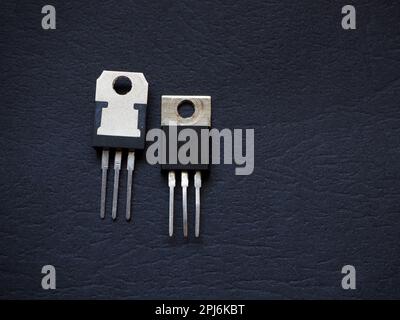 Transistor, triode, triac, mosfet ou tristor sur fond noir. Composants semi-conducteurs. Banque D'Images