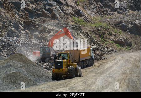 Travaux de construction pour la route. La pelle hydraulique charge des roches dans le tombereau. Chantier de construction de routes Banque D'Images