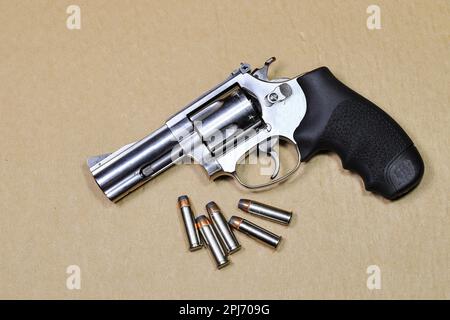 Pistolet revolver compact, vue latérale gauche du pistolet j-frame M60, avec cylindre fermé, prêt à l'emploi isolé sur papier marron. Banque D'Images