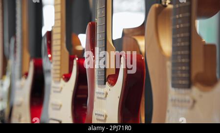 Guitares électriques exposées dans un magasin d'instruments, accrochées au mur, prises de vue en gros plan. Banque D'Images