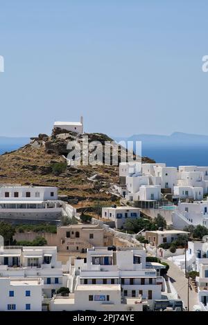 IOS, Grèce - 26 mai 2021 : vue sur divers hôtels blanchis à la chaux, une église au sommet de la colline et la mer Égée en arrière-plan dans iOS Grèce Banque D'Images