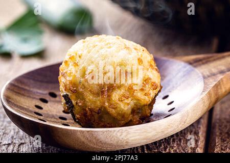 boulettes de morue, boulettes de viande de poisson dans une cuillère à fentes, sautées, macrophotographie Banque D'Images