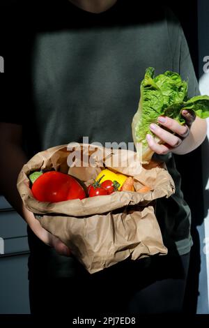 gros plan des mains tenant la laitue verte, sac de papier rempli de légumes Banque D'Images