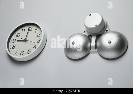 Horloge et cloche électriques modernes sur mur blanc Banque D'Images