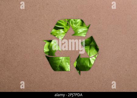 Symbole de recyclage en feuilles vertes sur papier kraft Banque D'Images