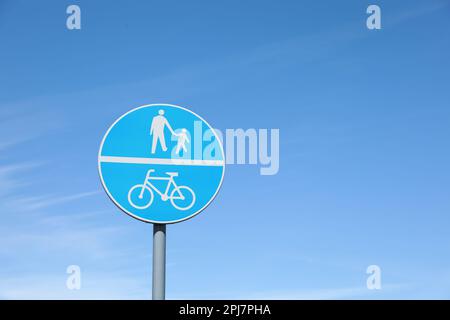 Signalisation routière obligatoire voie pour piétons et bicyclettes contre ciel bleu Banque D'Images