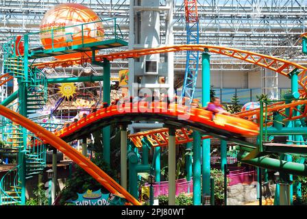 Une promenade en montagnes russes emmène les gens rapidement dans le parc d'attractions intérieur de Nickelodeon Universe, dans le Mall of America, Minnesota Banque D'Images