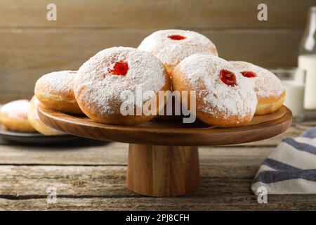 Présentoir à pâtisseries avec de délicieux beignets en gelée sur une table en bois Banque D'Images