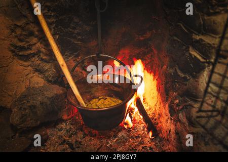 Chaudron à polenta sur le feu dans une maison rurale cheminée Banque D'Images