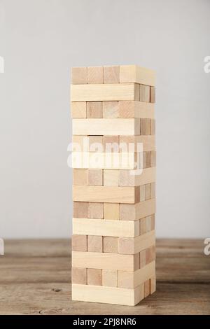 Concept de risque commercial avec jeu de bois jenga. Blocs de bois sur fond gris Banque D'Images