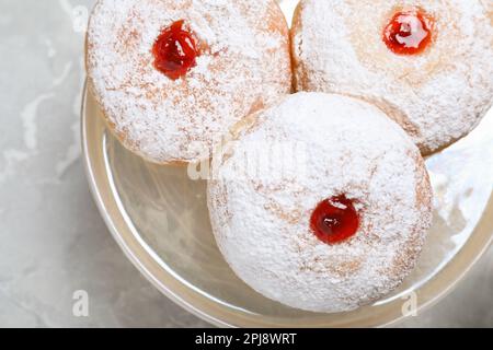 Délicieux beignets avec de la gelée et du sucre en poudre sur un présentoir à pâtisseries, gros plan Banque D'Images