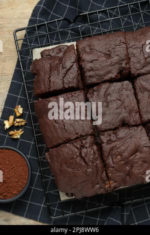 Délicieux brownies fraîchement cuits, poudre de cacao et noix sur une table en bois, plat Banque D'Images