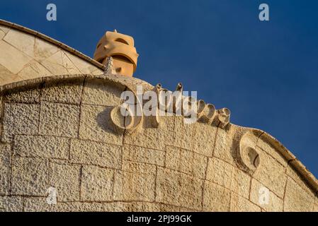 Détail de la garniture supérieure de la façade de la Pedrera - Casa Milà et une cheminée sur le toit (Barcelone, Catalogne, Espagne) Banque D'Images