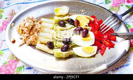 Assiette combinée d'oeufs, d'asperges, d'artichauts, de poivre de piquillo et de thon dans l'huile Banque D'Images