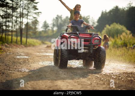 Les jeunes filles extrêmes font des quads sur une route dans la nature. Banque D'Images