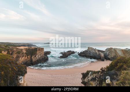 La beauté de la plage de sable de Praia dos Buizinhos avec les falaises de Porto Covo au coucher du soleil dans l'ouest du Portugal, au début de la randonnée de Rota Vicentina. Banque D'Images