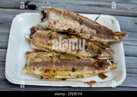 Sélection de poissons mullets grillés au blé gran, nettoyés et servis dans une assiette blanche jetable, cuisine de fruits de mer de mullet grillé égyptien, de Banque D'Images