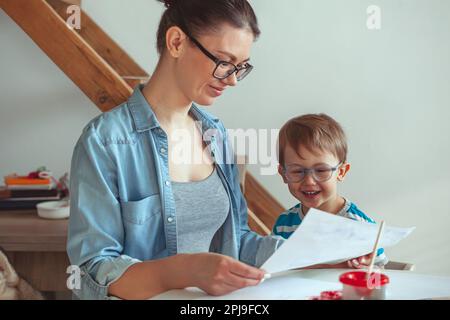 Maman et enfant peignent ensemble à la maison avec le chien Banque D'Images