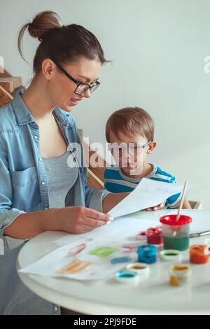 Maman et enfant peignent ensemble à la maison avec le chien Banque D'Images