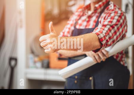 le travailleur de la main de construction pouces vers le haut pour le bon symbole satisfait comme l'amour des travaux finis Banque D'Images