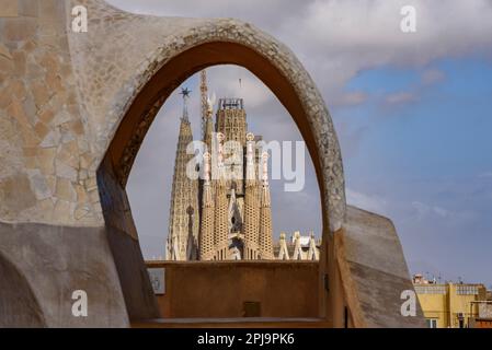 La façade passion de la Sagrada Família vue derrière une arche de la Casa Milà - la Pedrera (Barcelone, Catalogne, Espagne) Banque D'Images