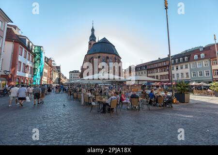 Les gens dans les cafés et les bars de Marktplatz - place du marché dans la vieille ville historique à côté de l'église du Saint-Esprit ou Heiliggeistkirche. Heidelberg. Banque D'Images