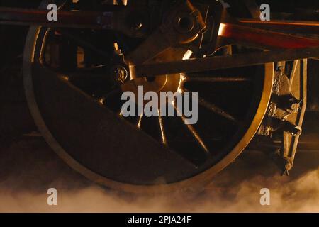 vapeur de la roue de fer de locomotive avec de la fumée flottant sur le chemin de fer la nuit Banque D'Images