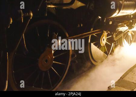 vapeur de la roue de fer de locomotive avec de la fumée flottant sur le chemin de fer la nuit Banque D'Images