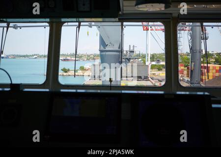 Vue depuis le pont du capitaine du transporteur de vrac jusqu'au poste de charge en vrac. Vue sur le terminal du port depuis l'intérieur du pont du capitaine pendant la journée Banque D'Images