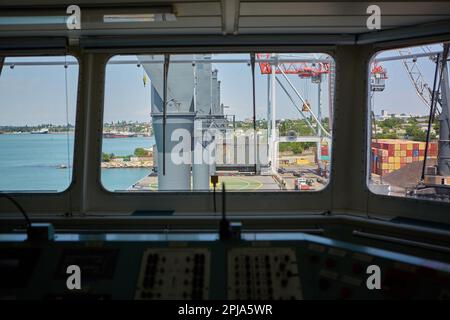 Vue depuis le pont du capitaine du transporteur de vrac jusqu'au poste de charge en vrac. Vue sur le terminal du port depuis l'intérieur du pont du capitaine pendant la journée Banque D'Images