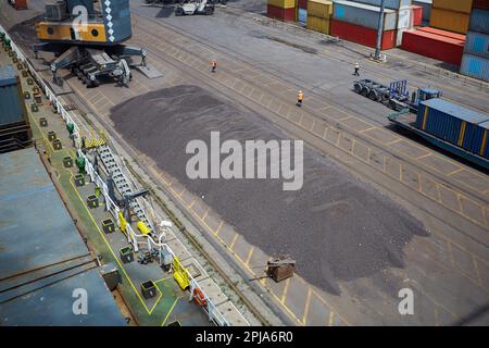 Opérations avec du charbon dans le port maritime. Chargement du charbon sur le transporteur de vrac. Chargement du charbon par des grues sur un transporteur de vrac Banque D'Images