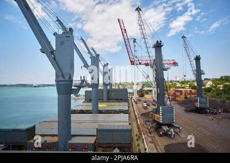 Opérations avec du charbon dans le port maritime. Chargement du charbon sur le transporteur de vrac. Chargement du charbon par des grues sur un transporteur de vrac Banque D'Images