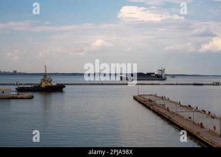 Bateau à remorqueurs dans le port avec navire à conteneurs à l'arrière-plan Banque D'Images