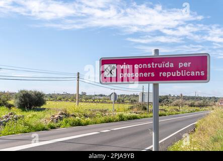 Panneau écrit en catalan expliquant que la route a été construite par les prisonniers républicains sous le régime de Franco, après la guerre civile espagnole. Santanyi, île o Banque D'Images