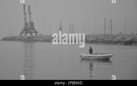 Rijeka, Croatie janvier 2023.bateau de pêche redirigeant vers le port par temps brumeux. Pêcheur dans le bateau près du port de Rijeka Banque D'Images