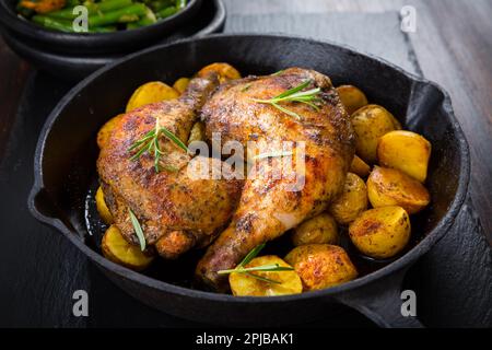 Cuisses de poulet au four avec des pommes de terre et légumes Banque D'Images