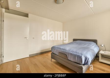 une chambre avec un lit, une commode et un miroir sur le mur en face de la chambre est de couleur très blanche Banque D'Images