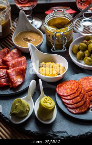 Assortiment de tapas et d'antipasti sur fond noir. Tableaux de charcuterie de divers hors-d'œuvre Banque D'Images