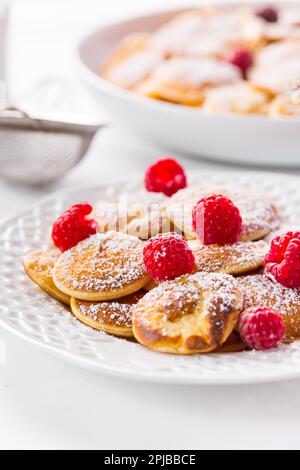 Poffertjes - petites crêpes hollandaises aux framboises fraîches. Cuisine hollandaise traditionnelle Banque D'Images